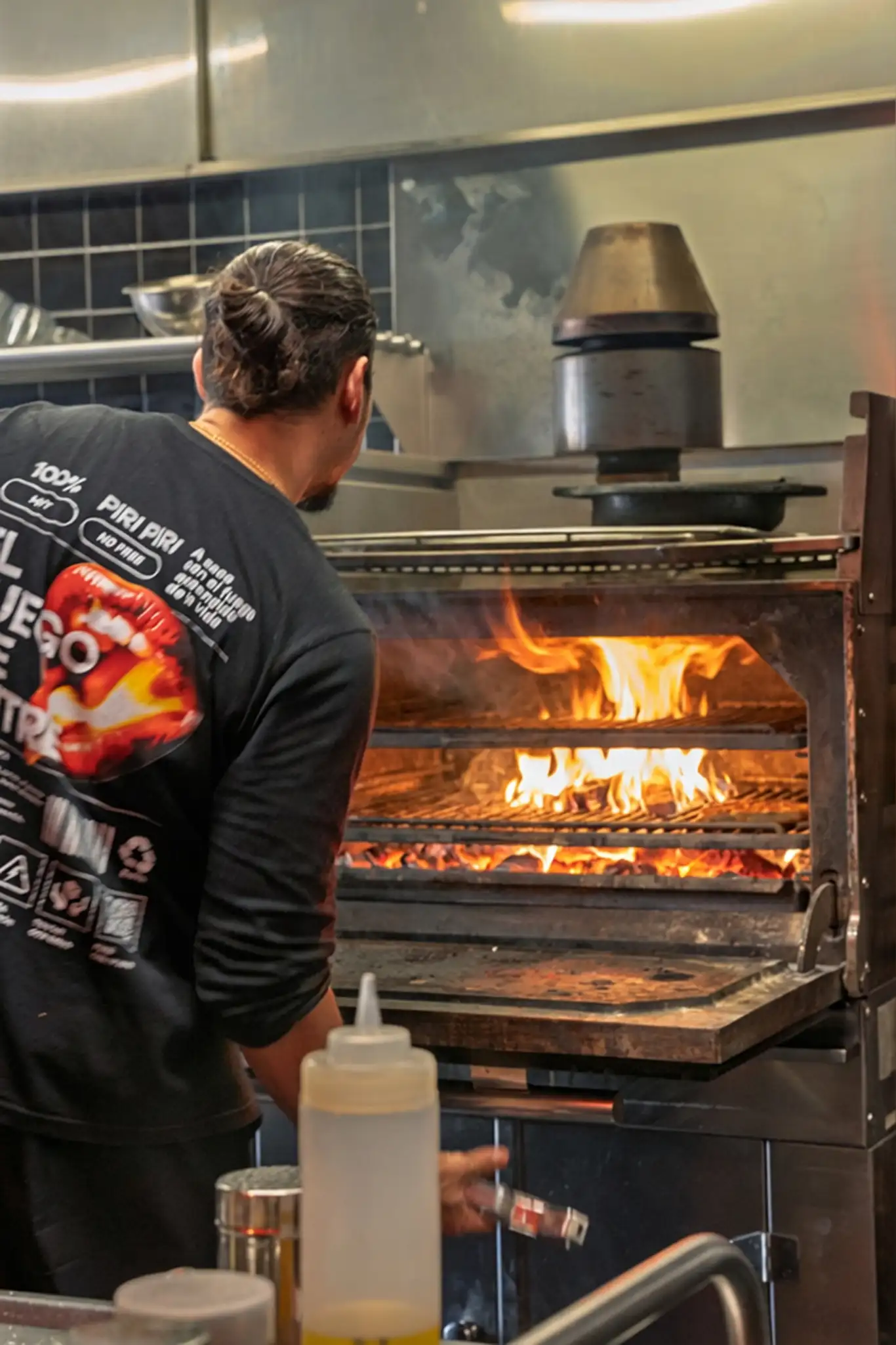 Un cocinero de Piri Piri frente al horno de carbón encendido