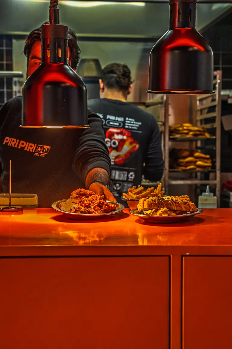 El pase de Piri Piri bajo las lámparas de calor con los platos listos